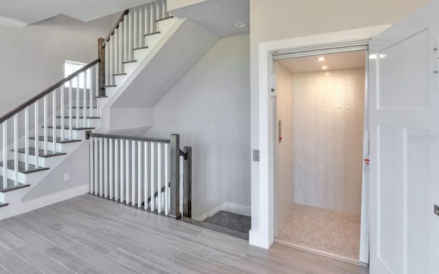 stairway featuring baseboards, recessed lighting, and wood finished floors