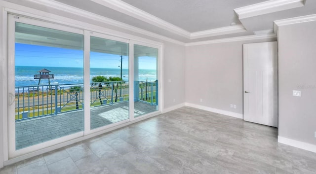 unfurnished room featuring crown molding, baseboards, a water view, and a tray ceiling