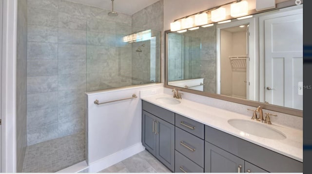 bathroom featuring a sink, walk in shower, double vanity, and a spacious closet