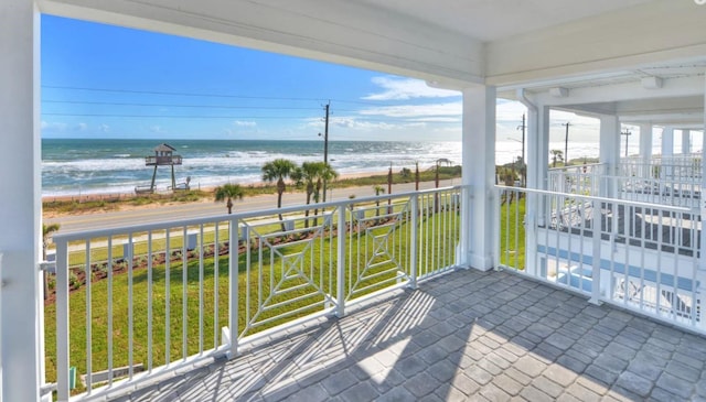 balcony featuring a beach view and a water view