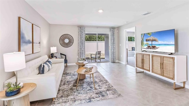 living area featuring light tile patterned flooring, baseboards, and visible vents