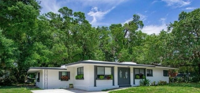view of front facade with stucco siding and a front yard