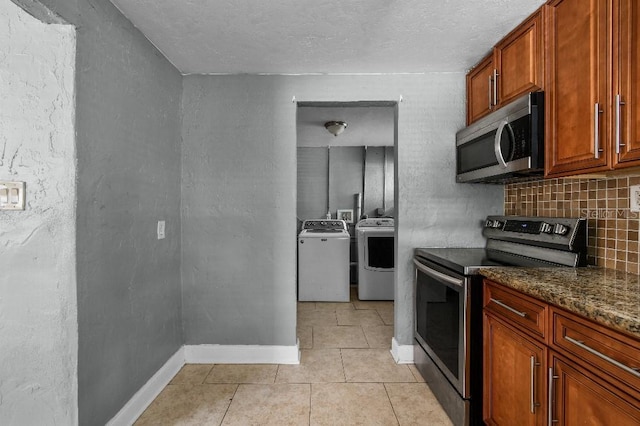 2026 Cocoanut Ave, Sarasota, FL 34234 - kitchen featuring washing machine and dryer, stainless steel appliances, baseboards, decorative backsplash, and light tile patterned flooring