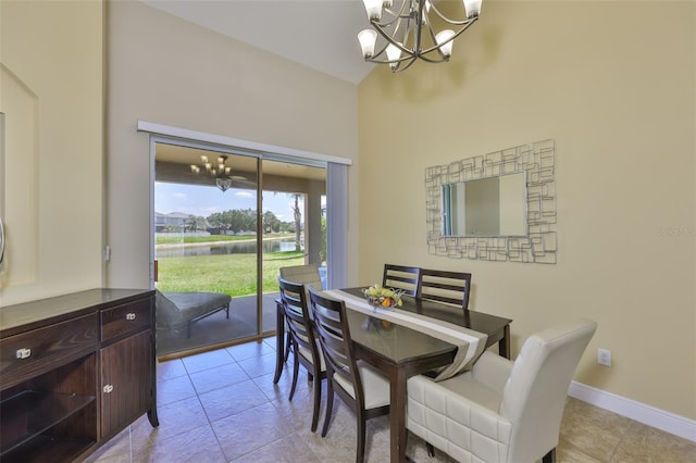 dining area with a water view, baseboards, a chandelier, and light tile patterned floors