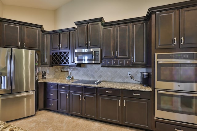 kitchen featuring backsplash, light tile patterned floors, appliances with stainless steel finishes, and light stone counters