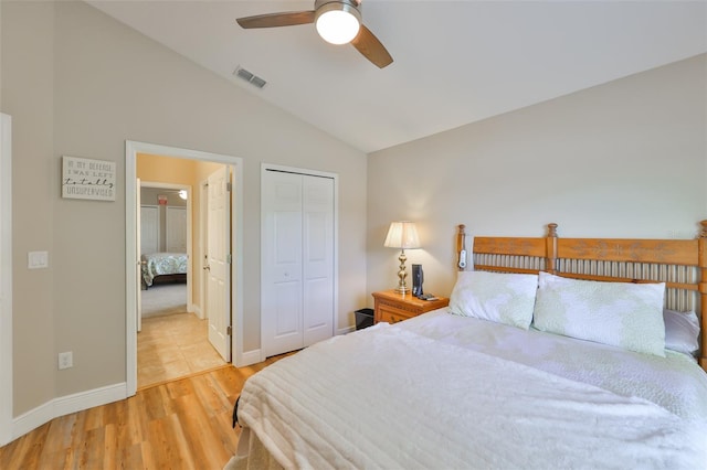 bedroom featuring visible vents, wood finished floors, baseboards, a closet, and lofted ceiling