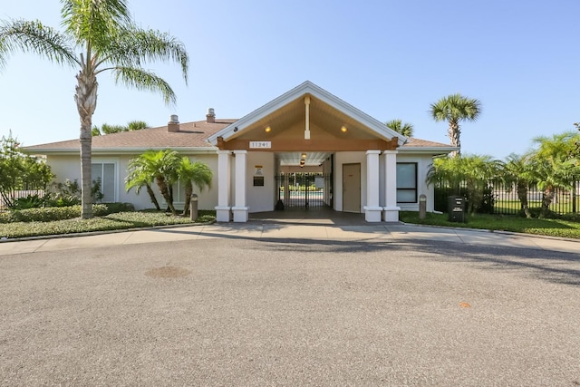 view of property featuring a carport, fence, and concrete driveway