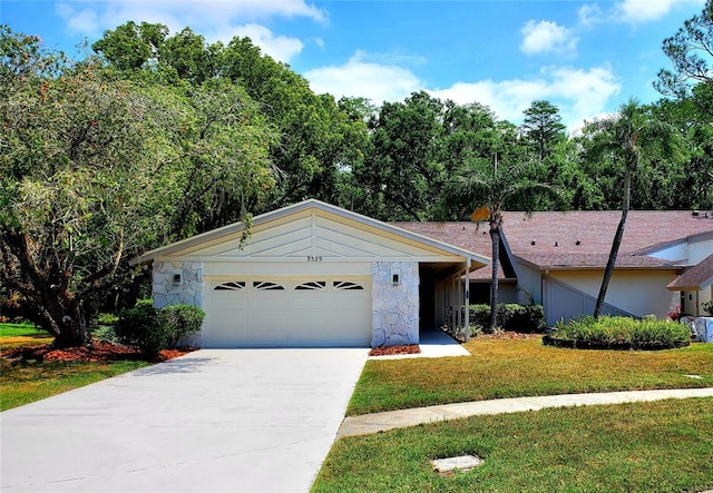 3529 Tanglewood Trl, Palm Harbor, FL 34685 - ranch-style house with a garage, a front lawn, driveway, and stone siding