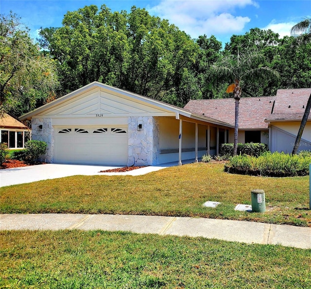 3529 Tanglewood Trl, Palm Harbor, FL 34685 - ranch-style home featuring an attached garage, a front lawn, driveway, and stone siding