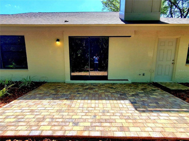 3529 Tanglewood Trl, Palm Harbor, FL 34685 - property entrance with a shingled roof, a patio area, and stucco siding