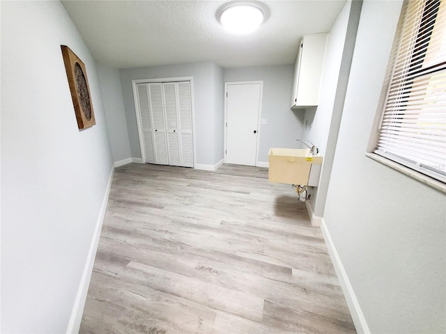 3529 Tanglewood Trl, Palm Harbor, FL 34685 - laundry room featuring a sink, baseboards, and light wood finished floors