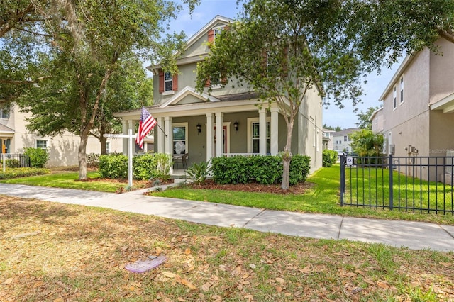 view of front of house with a porch, fence, a front yard, and stucco siding