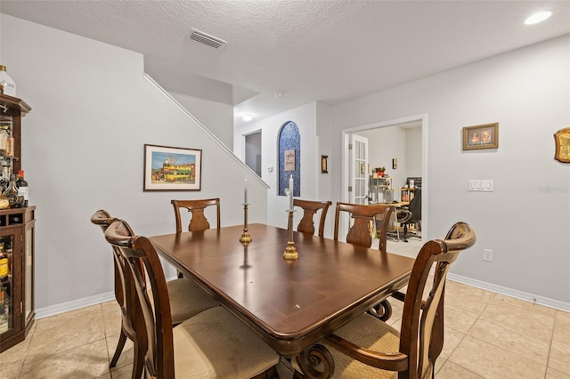 dining area featuring baseboards, visible vents, and light tile patterned floors