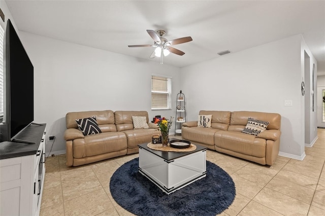 living room with a ceiling fan, baseboards, visible vents, and light tile patterned floors