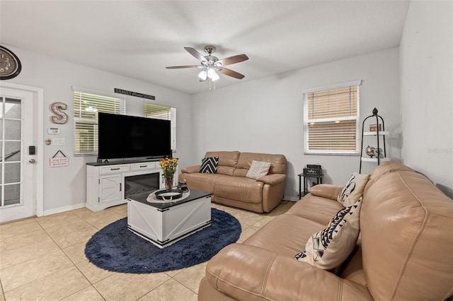 living room with baseboards, ceiling fan, and light tile patterned flooring