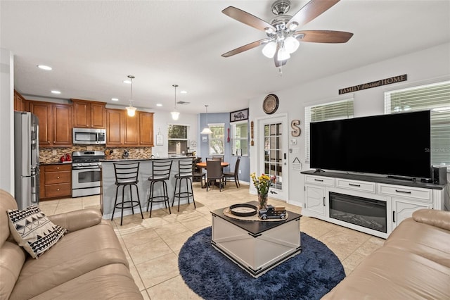 living area featuring recessed lighting, ceiling fan, and light tile patterned floors