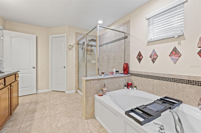 bathroom featuring a textured ceiling, vanity, a shower stall, and a bath