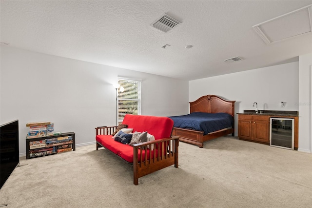 bedroom featuring beverage cooler, wet bar, visible vents, and light colored carpet
