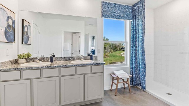 35896 Sunflower Hill Dr, Zephyrhills, FL 33541 - bathroom with a sink, tiled shower, tile patterned floors, and double vanity