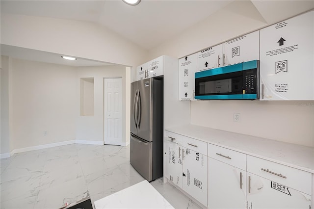 2167 Corfell St, Port Charlotte, FL 33948 - kitchen with freestanding refrigerator, light marble finish flooring, white cabinetry, baseboards, and vaulted ceiling