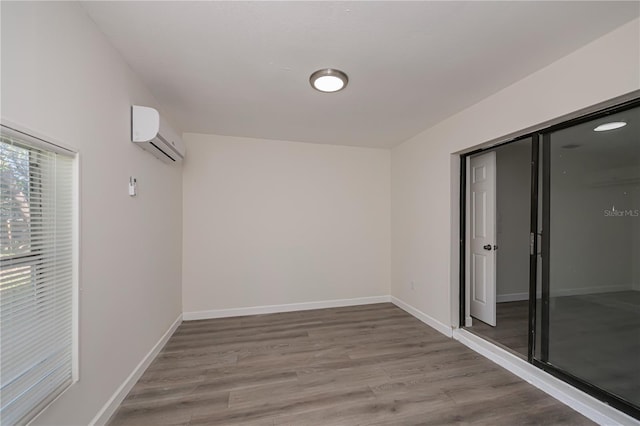 2167 Corfell St, Port Charlotte, FL 33948 - unfurnished room featuring an AC wall unit, wood finished floors, and baseboards