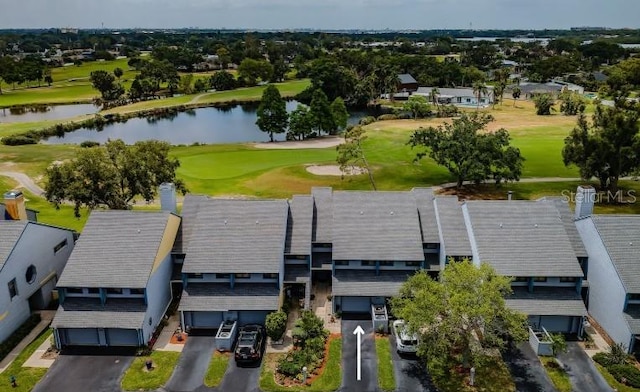 drone / aerial view with view of golf course and a water view
