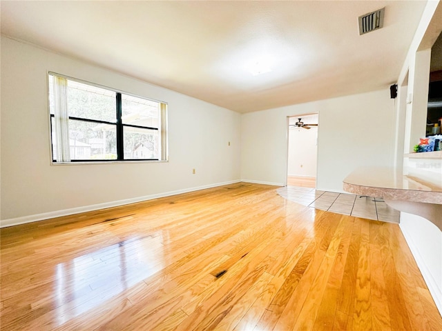 interior space featuring baseboards, visible vents, and light wood-type flooring