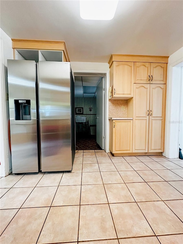 kitchen featuring stainless steel fridge, light brown cabinetry, and light tile patterned floors