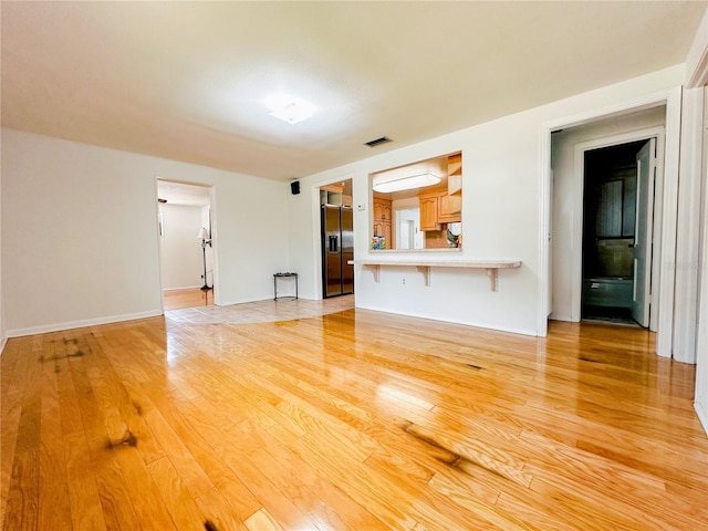 unfurnished living room featuring visible vents and light wood-type flooring