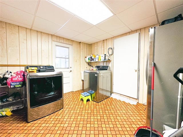 laundry room featuring laundry area, washer and clothes dryer, and wooden walls