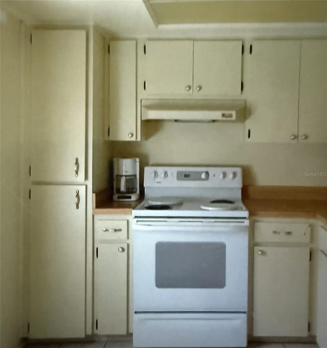 kitchen with under cabinet range hood, white range with electric stovetop, and light countertops