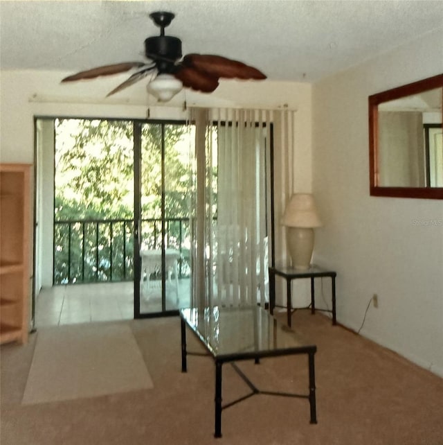 interior space featuring carpet floors, a ceiling fan, and a textured ceiling