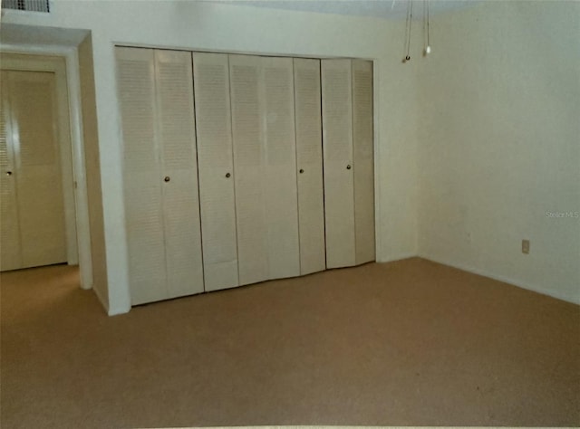 unfurnished bedroom featuring carpet floors and a closet