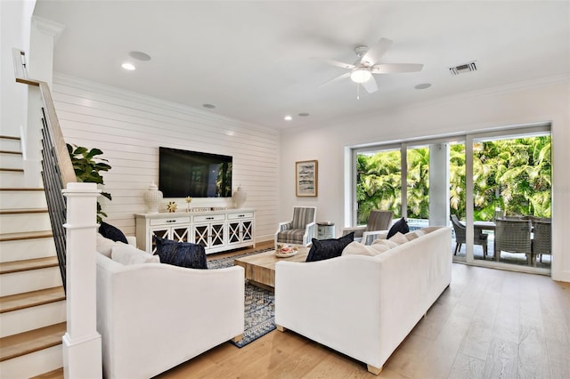 living area featuring ceiling fan, stairs, light wood-style flooring, ornamental molding, and recessed lighting