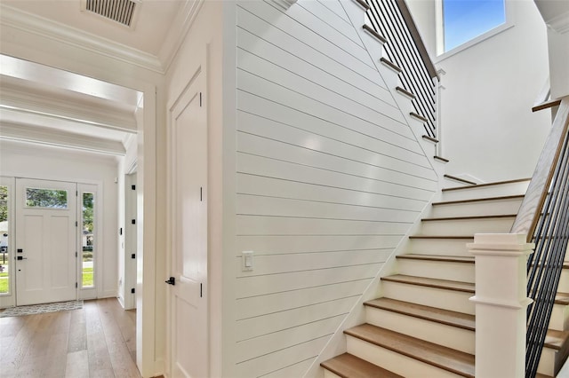 stairs featuring crown molding and hardwood / wood-style flooring