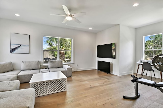 living area featuring plenty of natural light, ceiling fan, recessed lighting, light wood finished floors, and baseboards