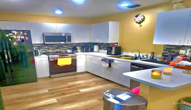 3086 Pointer Dr, Palm Harbor, FL 34683 - kitchen featuring stainless steel appliances, a sink, light countertops, backsplash, and a peninsula
