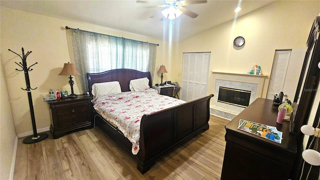 3086 Pointer Dr, Palm Harbor, FL 34683 - bedroom with vaulted ceiling, wood finished floors, a fireplace, baseboards, and a ceiling fan