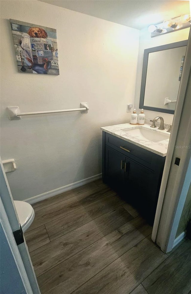 3086 Pointer Dr, Palm Harbor, FL 34683 - bathroom with wood finished floors, vanity, toilet, and baseboards