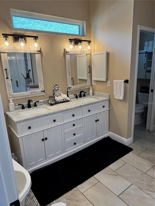 1747 Wood Brook St, Tarpon Springs, FL 34689 - bathroom featuring double vanity, toilet, a shower stall, and baseboards