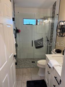 1747 Wood Brook St, Tarpon Springs, FL 34689 - bathroom with vanity, tile patterned flooring, a stall shower, and toilet