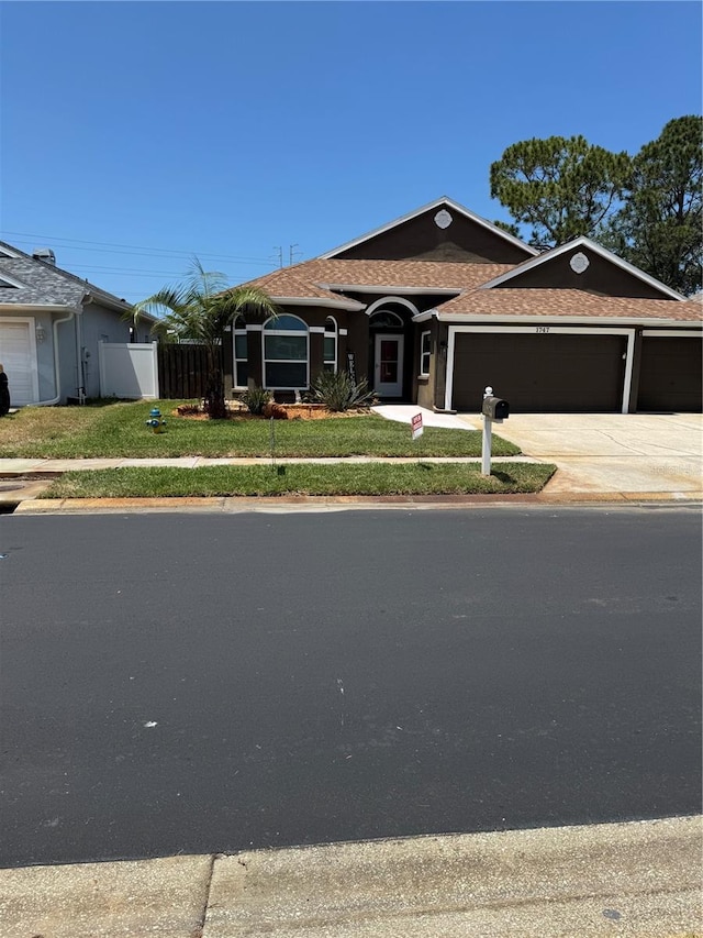 1747 Wood Brook St, Tarpon Springs, FL 34689 - ranch-style house with an attached garage, a shingled roof, and concrete driveway