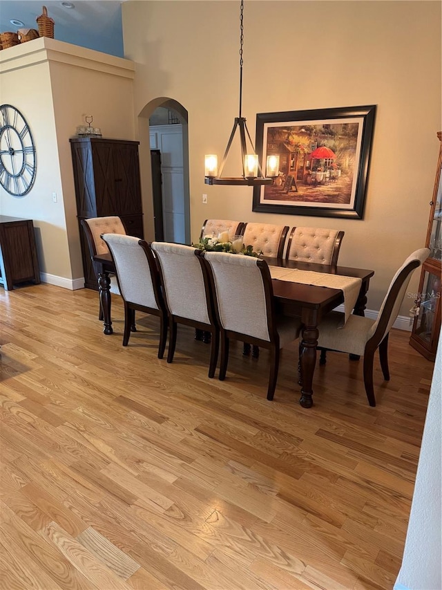 1747 Wood Brook St, Tarpon Springs, FL 34689 - dining area featuring arched walkways, light wood-style floors, baseboards, and a towering ceiling