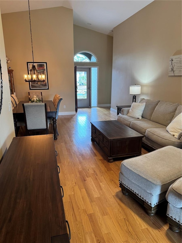 1747 Wood Brook St, Tarpon Springs, FL 34689 - living area with a chandelier, high vaulted ceiling, light wood-type flooring, and baseboards