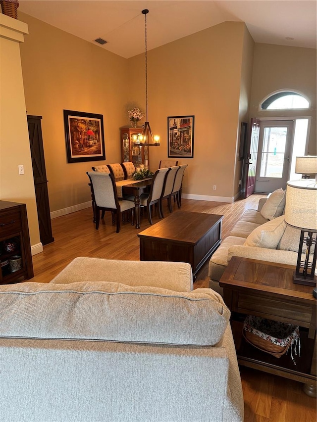 1747 Wood Brook St, Tarpon Springs, FL 34689 - living room with a chandelier, wood finished floors, baseboards, and high vaulted ceiling