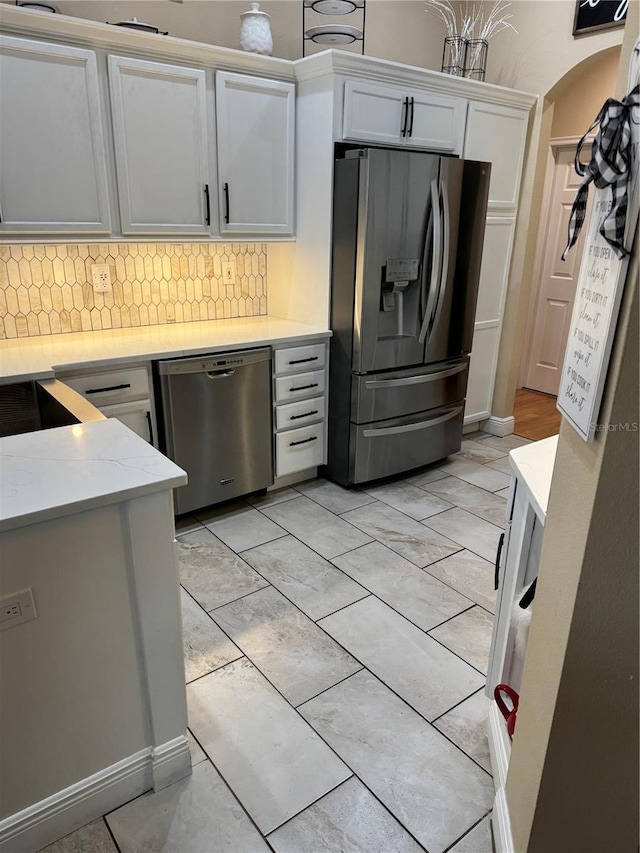 1747 Wood Brook St, Tarpon Springs, FL 34689 - kitchen with stainless steel appliances, backsplash, white cabinetry, and arched walkways