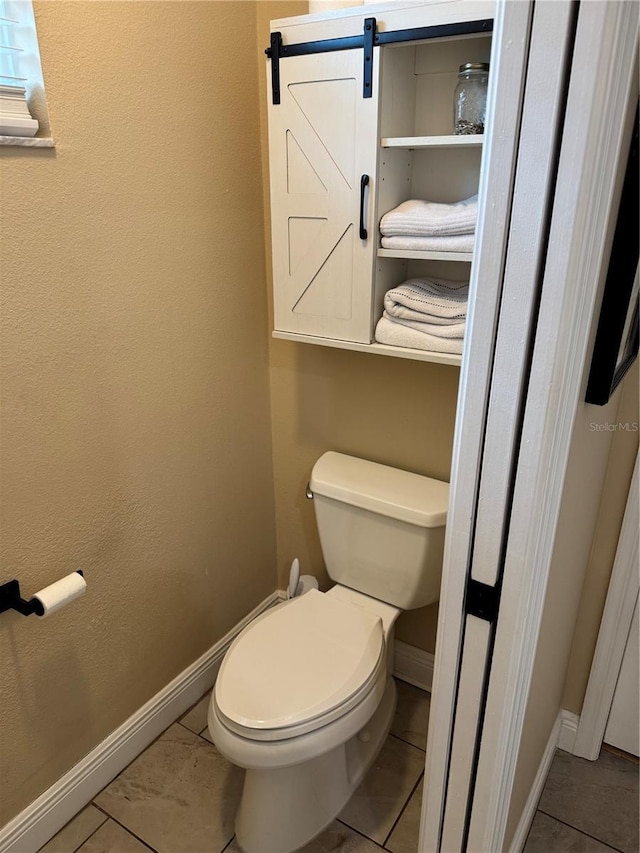 1747 Wood Brook St, Tarpon Springs, FL 34689 - bathroom with baseboards, toilet, and tile patterned flooring