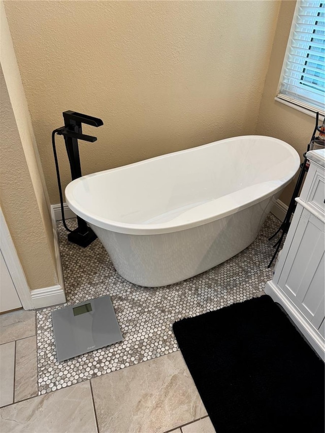 1747 Wood Brook St, Tarpon Springs, FL 34689 - full bathroom featuring a soaking tub, a textured wall, vanity, and baseboards