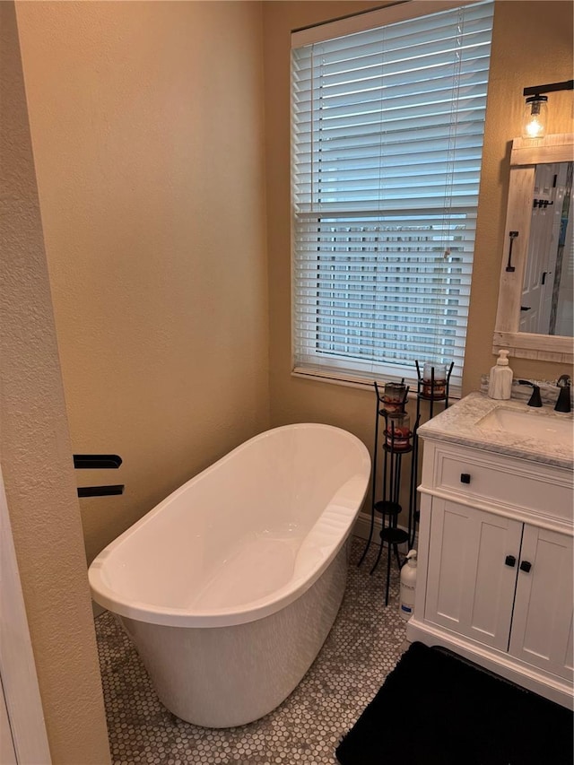 1747 Wood Brook St, Tarpon Springs, FL 34689 - bathroom featuring vanity, a soaking tub, tile patterned floors, and a textured wall