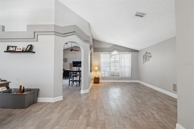 entrance foyer with visible vents, ceiling fan, wood finished floors, and lofted ceiling